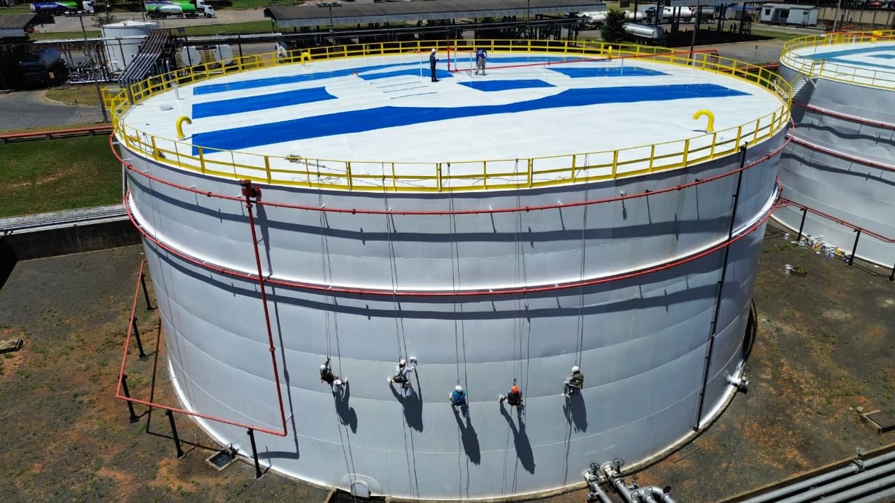Equipo de Pinceles pintando un tanque industrial con trabajo vertical
