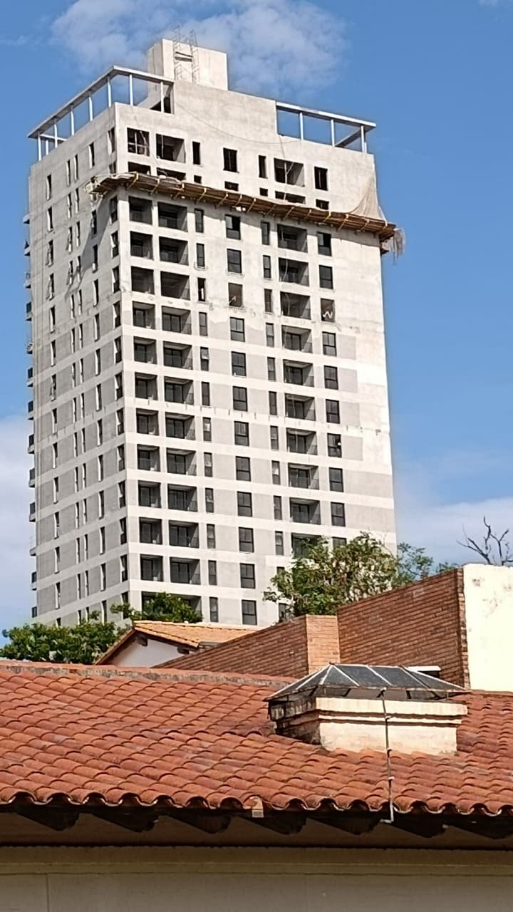 Torre residencial en construcción vista sobre techos de teja